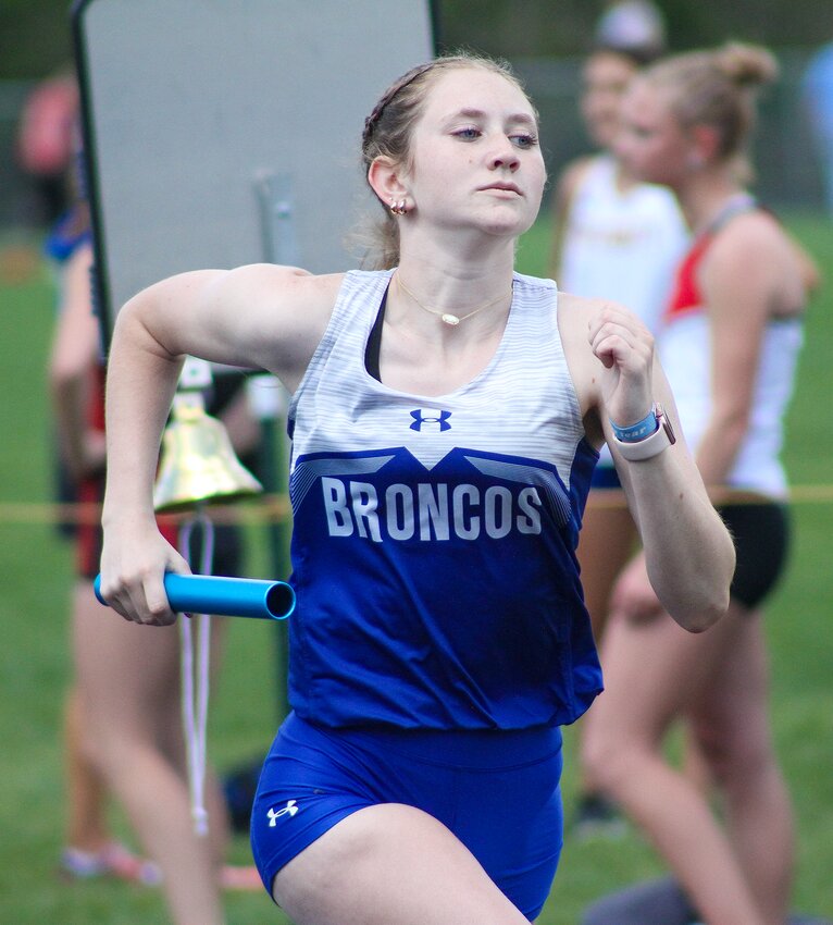 Nya Fischer of Centennial pumps her arms as she takes the baton during the 4X800m relay on May 3.