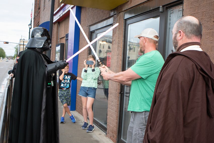 Ed McLaughlin of Seward pretends to battle Darth Vader as his daughter Clara, age 11, and son Derek, 8, look on prior to the showing of “Star Wars: Revenge of the Sith” at the Rivoli on April 30.