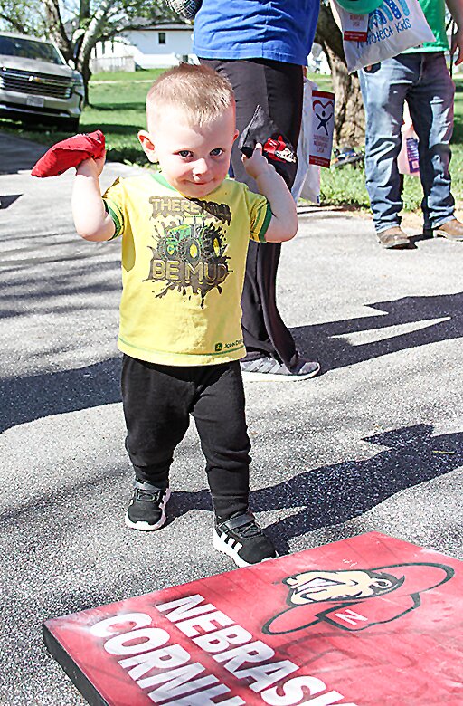 Hudson Ahrens, who will be 2 in June, shows his cornhole skills during a family fun night April 29 at Living Word Lutheran Church. The event was sponsored by Sixpence, CASA and Hope Crisis Center.