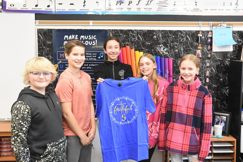 Holy Family School’s Faithful Five members — sixth graders Linus Dunn (from left), Karsten Saltmarsh, Raya Nathe, Quinncy Jennissen and Scarlette Deters — get out one of their T-shirts Feb. 26 at HFS in Sauk Centre. They will be competing in the Shine On contest Sunday, March 3, at Benilde-St. Margaret’s in St. Louis Park.