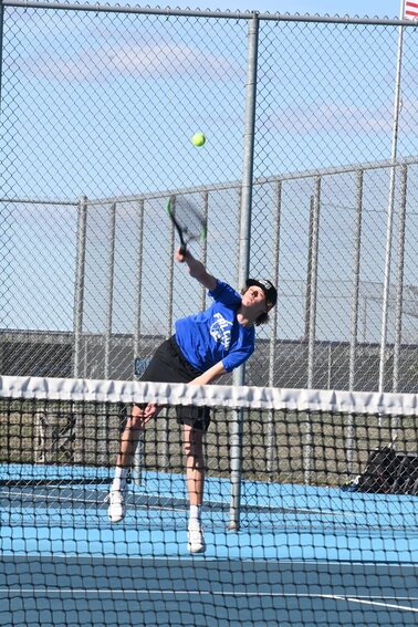 Colton Stangler delivers a powerful overhand serve against the St. Cloud Crush April 12 at Foley High School in Foley. Stangler participated in a thrilling three-set battle at No. 2 singles, ending in a 1-6, 7-5, 3-6.