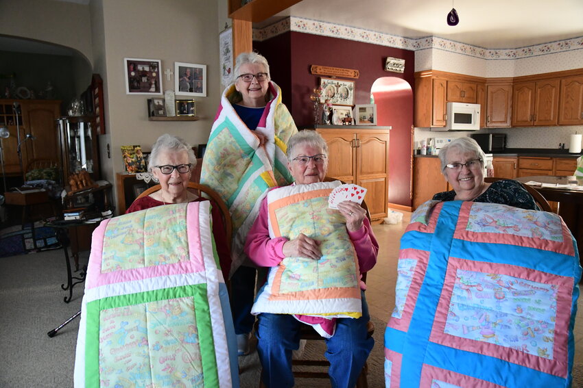 Florence Jaeger (front, from left), Dolores Rohe and Hildegard Rohe; and (back) Carol Klehr display quilters’ quilts Carol made and gifted to her sisters and herself April 12 in Carol’s rural St. Martin home. Quilting and card playing go hand-in-hand with these sisters who grew up in rural St. Martin.