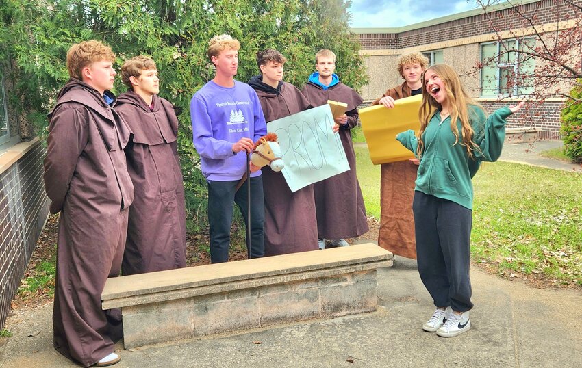 Crowned Andrew Drevlow and Serena Middendorf act out a medieval promposal from the week prior at the Sauk Centre High School courtyard April 19 in Sauk Centre. Accompanied by his royal entourage — Damian Ahrens, Austin Helgeson, Jeric Schloegl, Jay Neubert and Jacob Robischon — Drevlow rode a stick horse through the Dairy Queen drive-thru to ask Middendorf to prom.