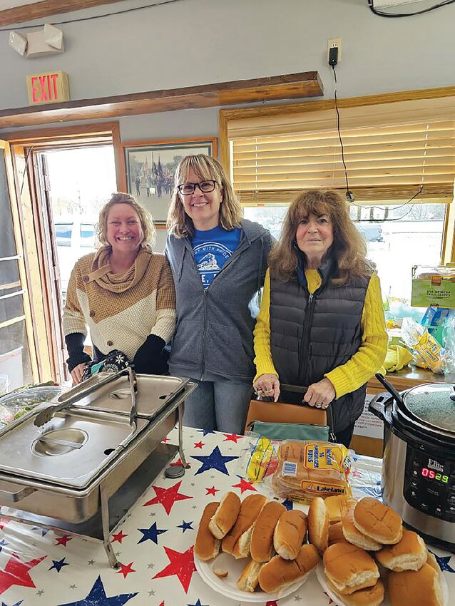 American Legion Post 473 Auxiliary members Mimi Rolfzen (from left), Sarah Midas and Mary Larson get ready to serve hot dogs and hamburgers prepared during the 2023 Family Day at the Legion in Rice. The success of the first-ever celebration in Rice convinced organizers Family Day should return this year to the post; the free gathering is set for Saturday, April 27.