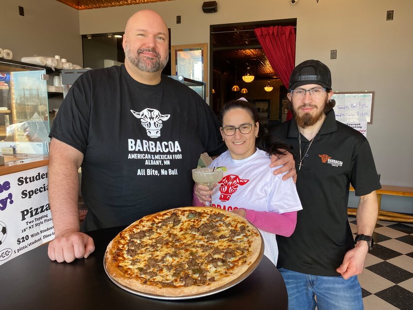 David Belford (from left), Doris Belford and Wilber Flores display a homemade pizza and margarita April 9 at Barbacoa Smokehouse & Deli in Albany. The Belfords completed a renovation of the lower level restaurant and bar and are working on the second story hotel.