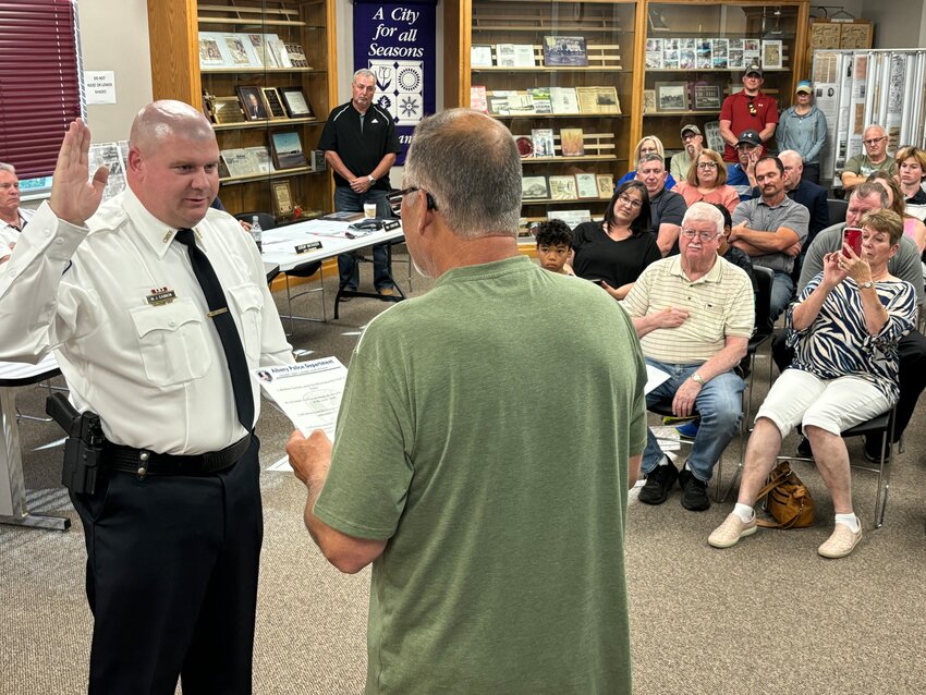 Matt Gannon (from left) raises his right hand as Mayor Tom Kasner administers the police chief oath of honor July 3 at Albany City Hall in Albany. The council chambers were filled to capacity for Gannon’s swearing-in ceremony at the start of the city meeting.