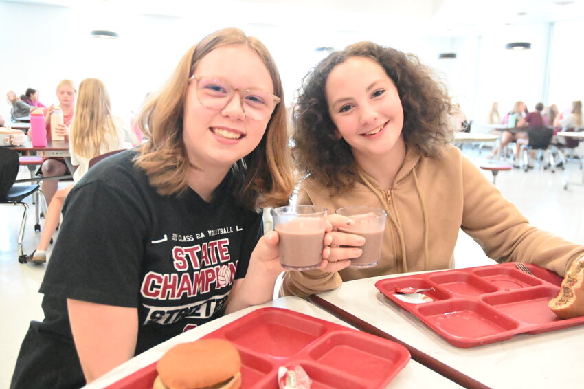 Kaylee Messer (left) and Kaylen Wolbeck eat lunch with their glasses of chocolate milk from the new bulk milk dispensers Sept. 13 in the Sauk Centre High School cafeteria in Sauk Centre. Wolbeck said she likes the milk, with chocolate being her favorite.