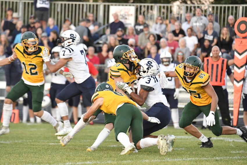 Storm sophomore linebacker Carter Pesta (23) and junior Levi Brenny (85) join forces to tackle St. Francis running back Jacob Tilly Friday at Sauk Rapids-Rice High School Stadium in Sauk Rapids. The Storm won their homecoming game 28-14 over the Saints.