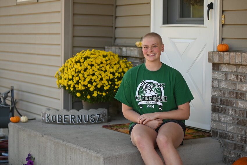 Emma Kobernusz dons her track and field All-Conference shirt at her family’s home Sept. 28 in Holdingford. Kobernusz is a Holdingford High School student-athlete who was diagnosed with Hodgkin lymphoma in March.