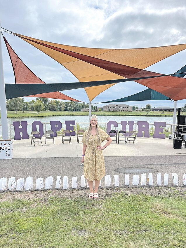 Courtney Nelson smiles in front of luminaries lining the sidewalk near Lake Francis Sept. 14 during the Relay for Life of Central Minnesota in Sartell. Nelson, a Foley resident and a fifth-grade teacher at St. Cloud Math and Science Academy, spoke during the event’s opening ceremony as an honorary survivor.