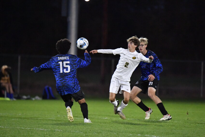 Storm junior forward Austin Markfelder battles for the ball with two Sartell opponents as his team faced the Sabres Oct. 3 at the Sartell High School fields in Sartell. Markfelder led Sauk Rapids-Rice in the regular season with 10 goals.