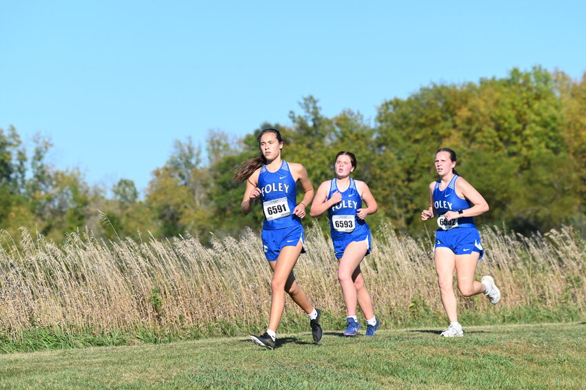 Maya Rahm (left) pushes herself as she runs as part of a pack with Foley teammates Marissa Seidel (center) and Lenora Johnson at the Falcon Invitational Sept. 26 at Foley High School in Foley. Rahm and fellow junior Annelise Jennissen have proven to be capable leaders for a Falcons team that has competed at both the varsity and junior varsity levels this season.