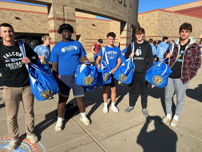 Foley High School football players Dakota Olson (from left), Elijah Dieger, Wyatt Lueck, Reed Hermanson and Cole Rueckert showcase new equipment bags with the American Legion emblem Oct. 8 in front of Foley High School in Foley. Foley Falcon Touchdown Club chose to adorn the bags with the American Legion logo because American Legion Post 298 donated $2,750 for the equipment in August.