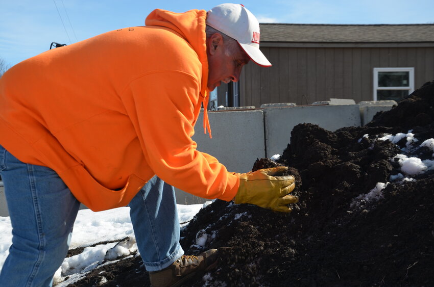 Jamie Phenow, site manager at Tri-County Organics, fills his hands with organic compost Feb. 24 at Tri-County Organics east of St. Cloud. Adding compost to soil can improve its physical, chemical and biological properties.
