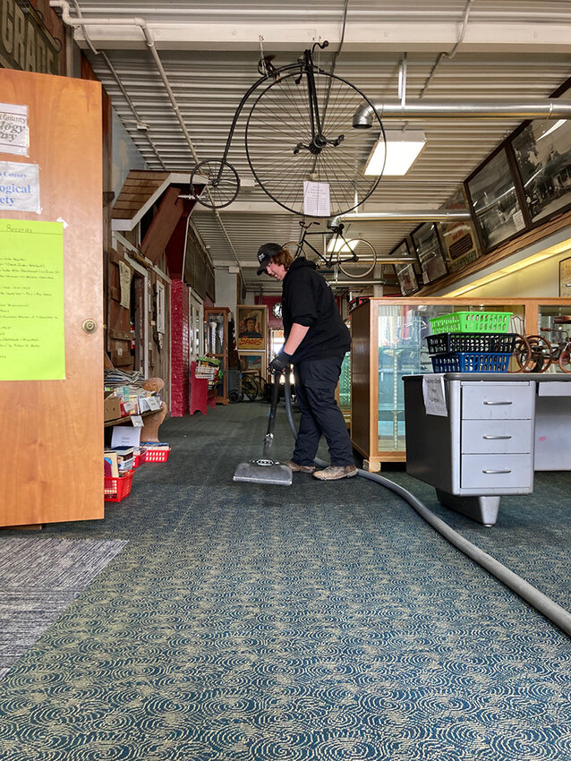 Servicemaster employee Drake Hollingsworth vacuums wet carpets in the Buena Vista County Historical Museum, which lost its entire roof.