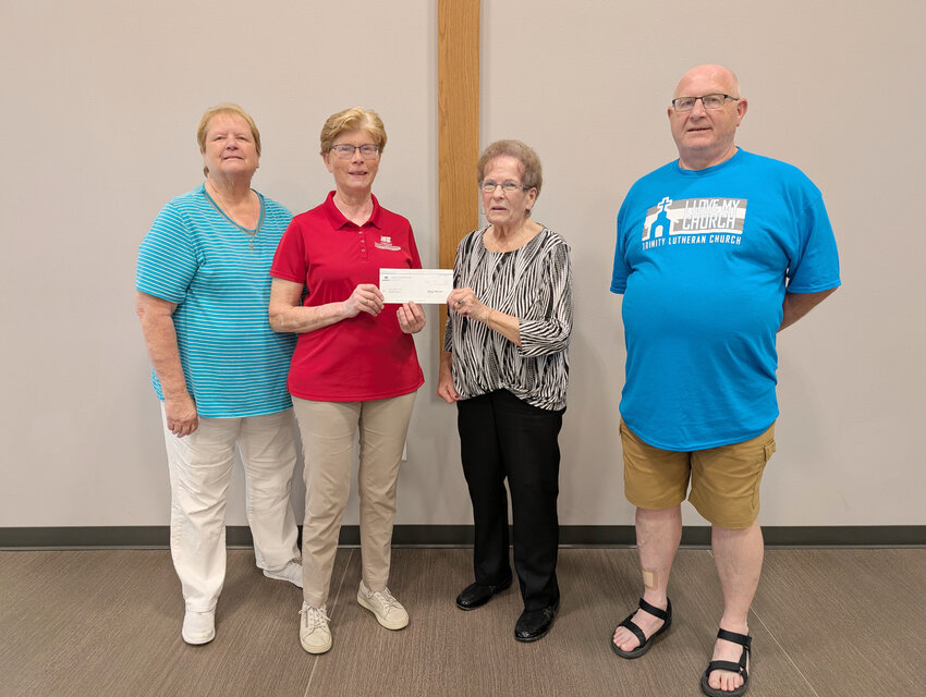 Elizabeth Johnson representing the Cherokee County Farm Bureau presenting Mary Scott, Shirley Beck, and Burton Friedrichsen a $200 check.