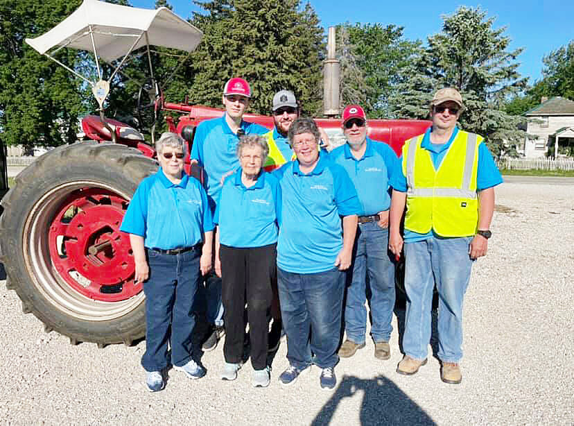 Here is the family again, as they host the annual Harold King Memorial Tractor Ride.  They are standing in front of the late Harold King’s Farmall 450 which he bought new in the late 1950s. This is the lead tractor in the annual ride. It also pulls a trolley for people who want to participate in the ride, but don't have a tractor. The event was initiated in 2016 and travels a different 50-60 mile route each year. Coffee and donuts in the morning and lunch at noon, organized by Marilyn and her daughters, make this outing special. Proceeds from the ride fund scholarships for young people going into the field of ag. Front row, from left: Harold’s daughter Denise King, wife Marilyn King, and daughter Julie Langner.  Back: grandson Daniel Langner; grandson Kirk Langner; president, coordinator and safety director of the ride son Kevin King and son Jeff King.