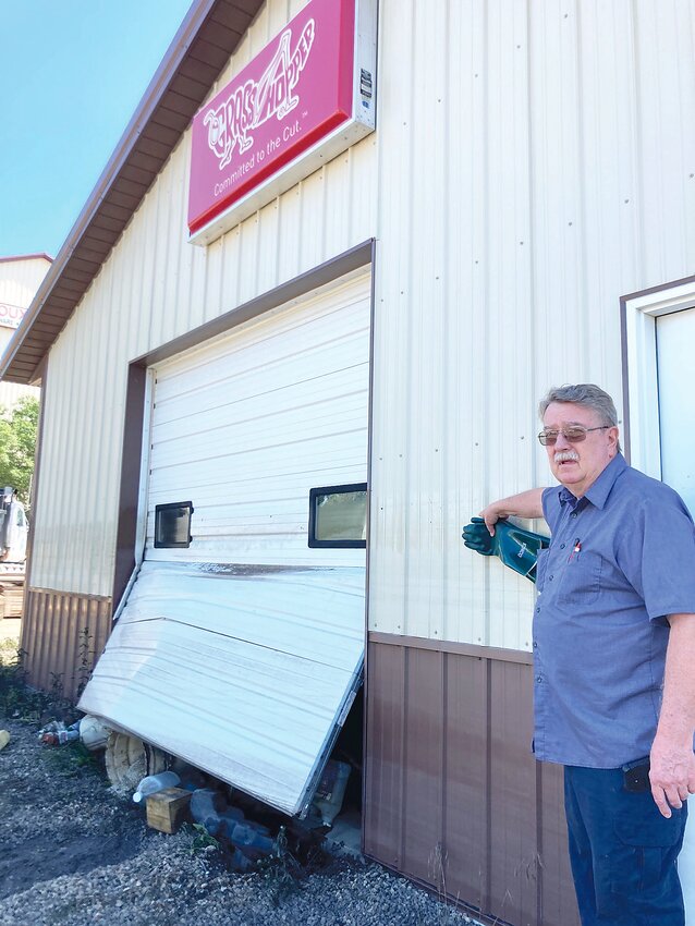 On June 24, Hondo points to where the water level rose on the east side of his building. A new door has been ordered to replace the damaged one.