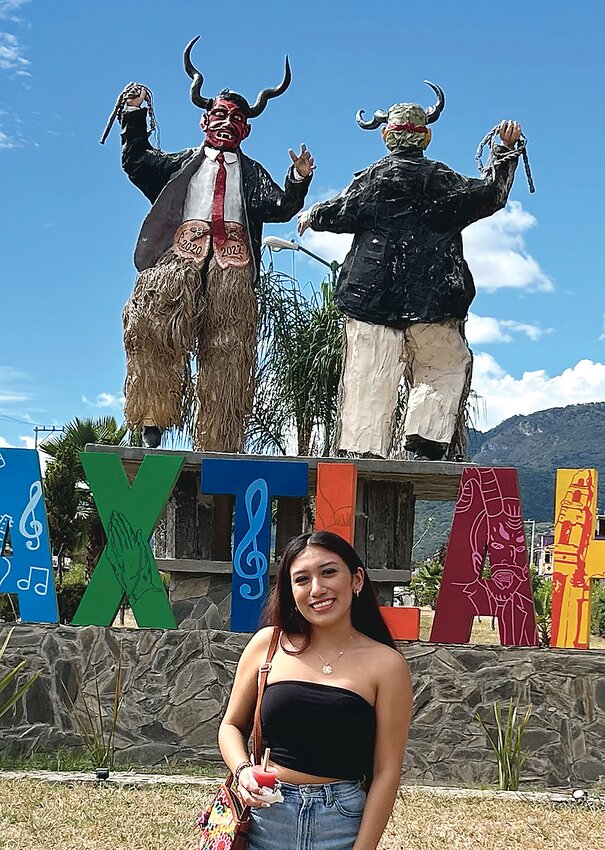 Marlene Colonel, 17, poses in front of statues representing 
“diablos” or devils. In Oaxaca, diablos in goat fur outfits, devil masks and horns represent the protest and rebellion of formerly enslaved Afro-indigenous peoples.