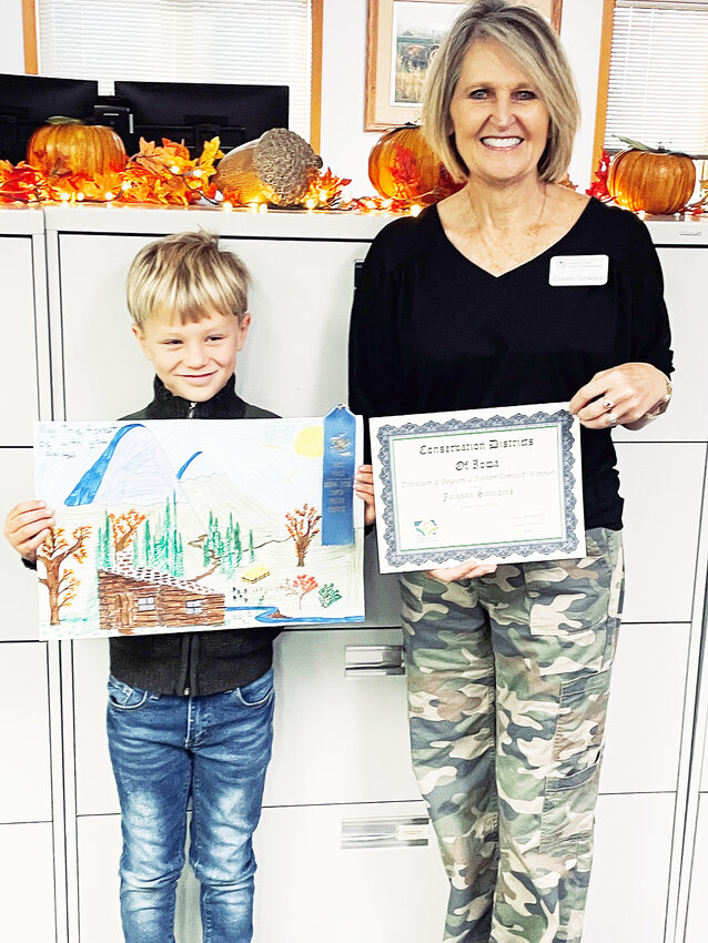 Colleen Schwanz with the Buena Vista Soil & Water Conservation District, presents Jackson with his certificate and check. Saunders is the son of Mark and Rachel Saunders of Peterson.