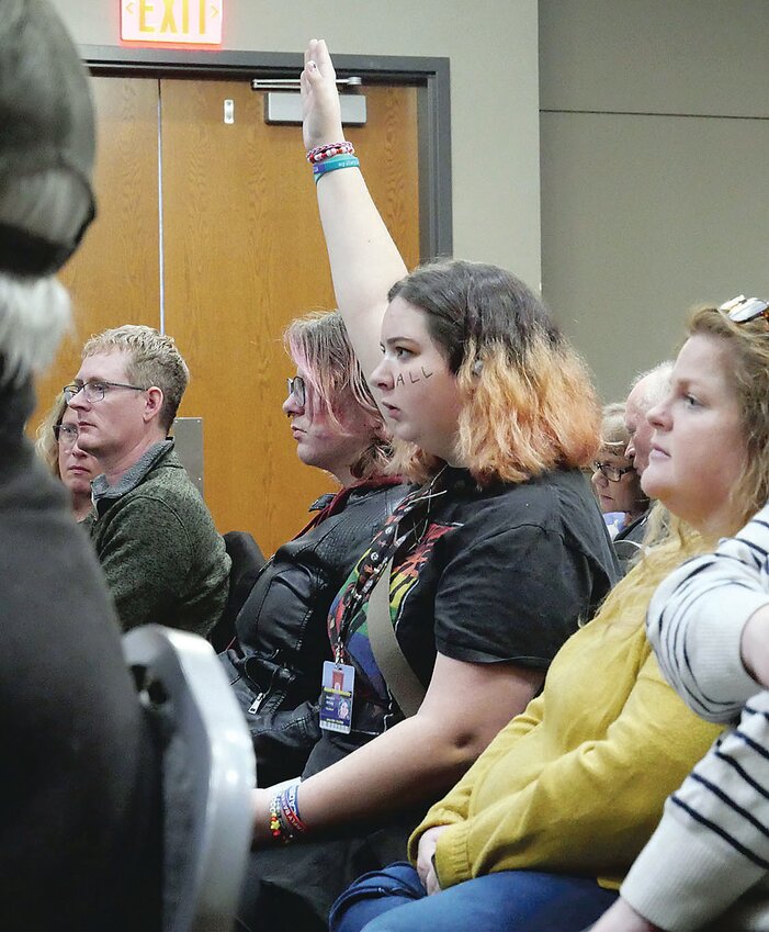 Kass Orwig's hand shoots up during a discussion about
legislation targeting undocumented immigrants. Orwig,
whose face paint reads “LOVE ALL,” and Michael
Probasco (left) spoke with Rep. Jones about their fears
as LGBTQ students in Iowa.