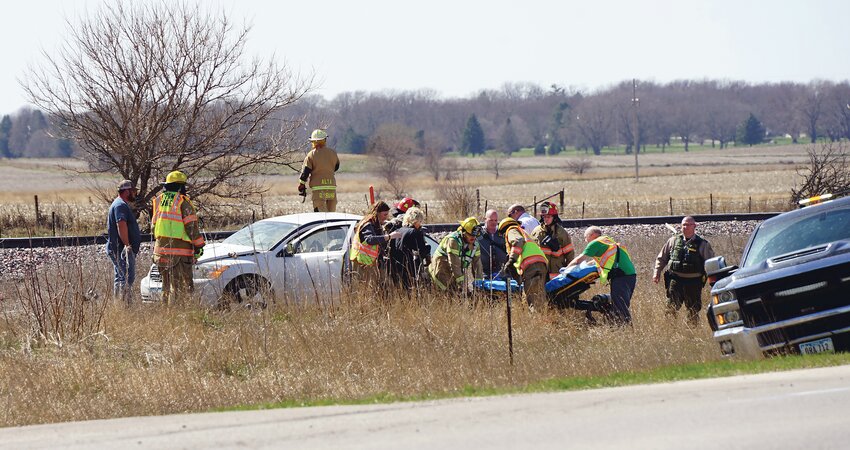 Storm Lake firefighters bring a stretcher for Marie Eckerman after her car was struck by the train.