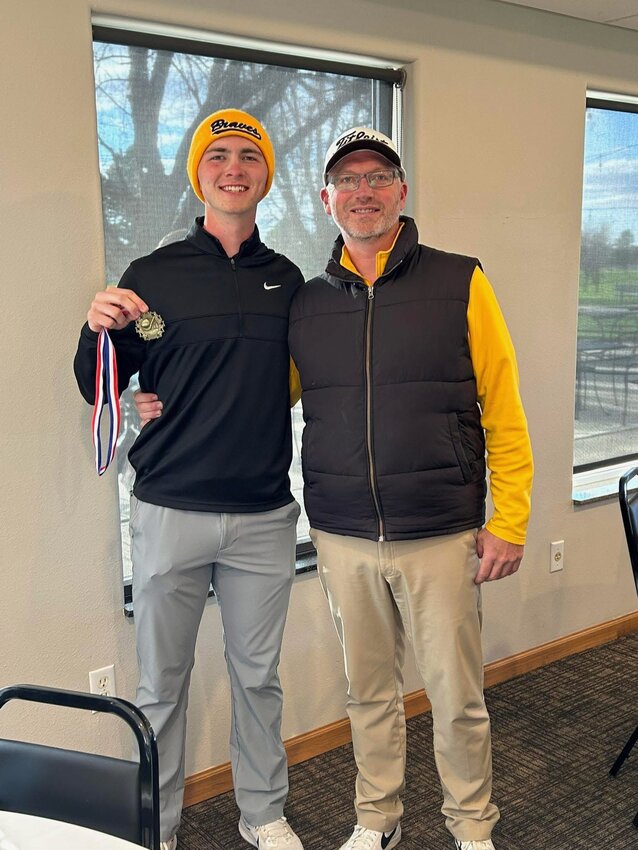 Drew Spooner, left, poses for a photo with his dad, Jason Spooner, after a golf meet.