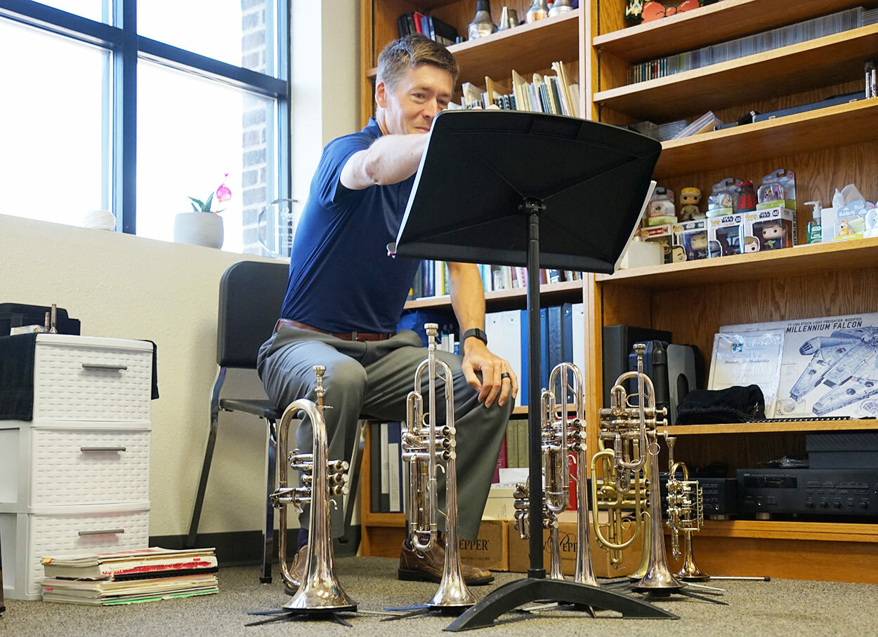 Norris’ main instrument is the trumpet and 
he owns a variety of them, as seen here in his 
office. Norris has a Doctor of Music Arts degree. 
He directs concert band, jazz band, pep band, 
marching band and teaches lessons. He previously taught at Williston State College in North Dakota.