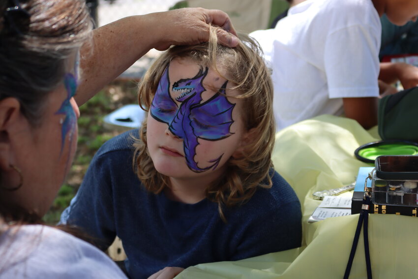 Fourth grader Dean Blomer gets a dragon face painting from Smiley Cheeks artist Carol Morgan.