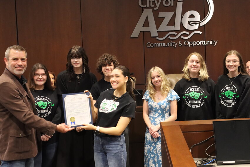 Azle Mayor Alan Brundrett presents a written proclamation to AHS Drama Club Vice President Lyla Castro in front of Sage Laing, TJ Bradford, Jonah Castro, Kayla Eversole, Savanna Samford and Rebecca Crabtree during the March 4 council meeting at Azle City Hall.