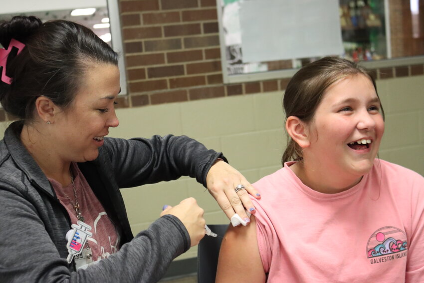 Courtney Overton, an 11-year-old Azle Elementary student, puts on a brave face for her flu shot from Misti Mills.