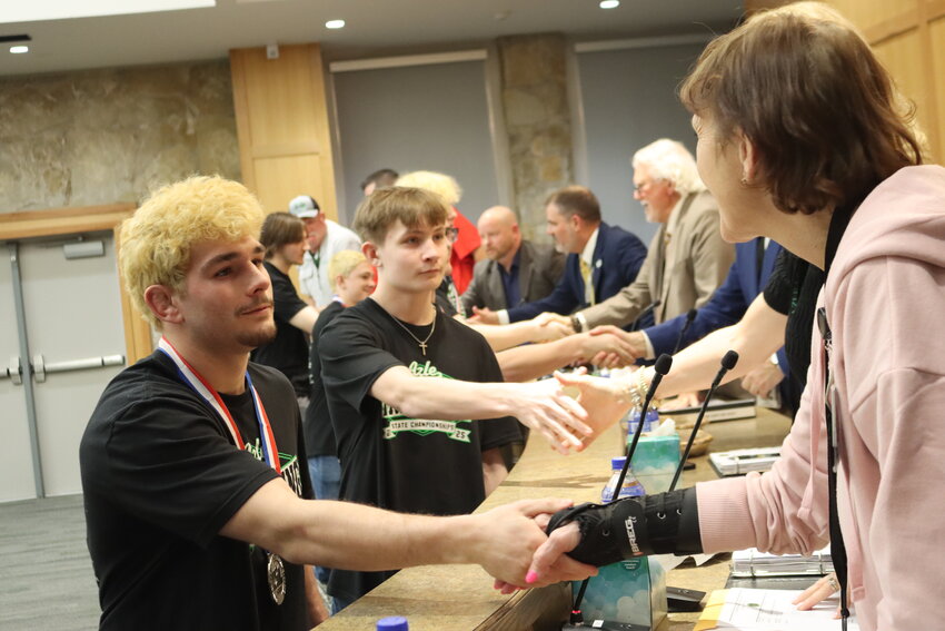 Azle High School wrestlers shake hands with trustees Feb. 24.