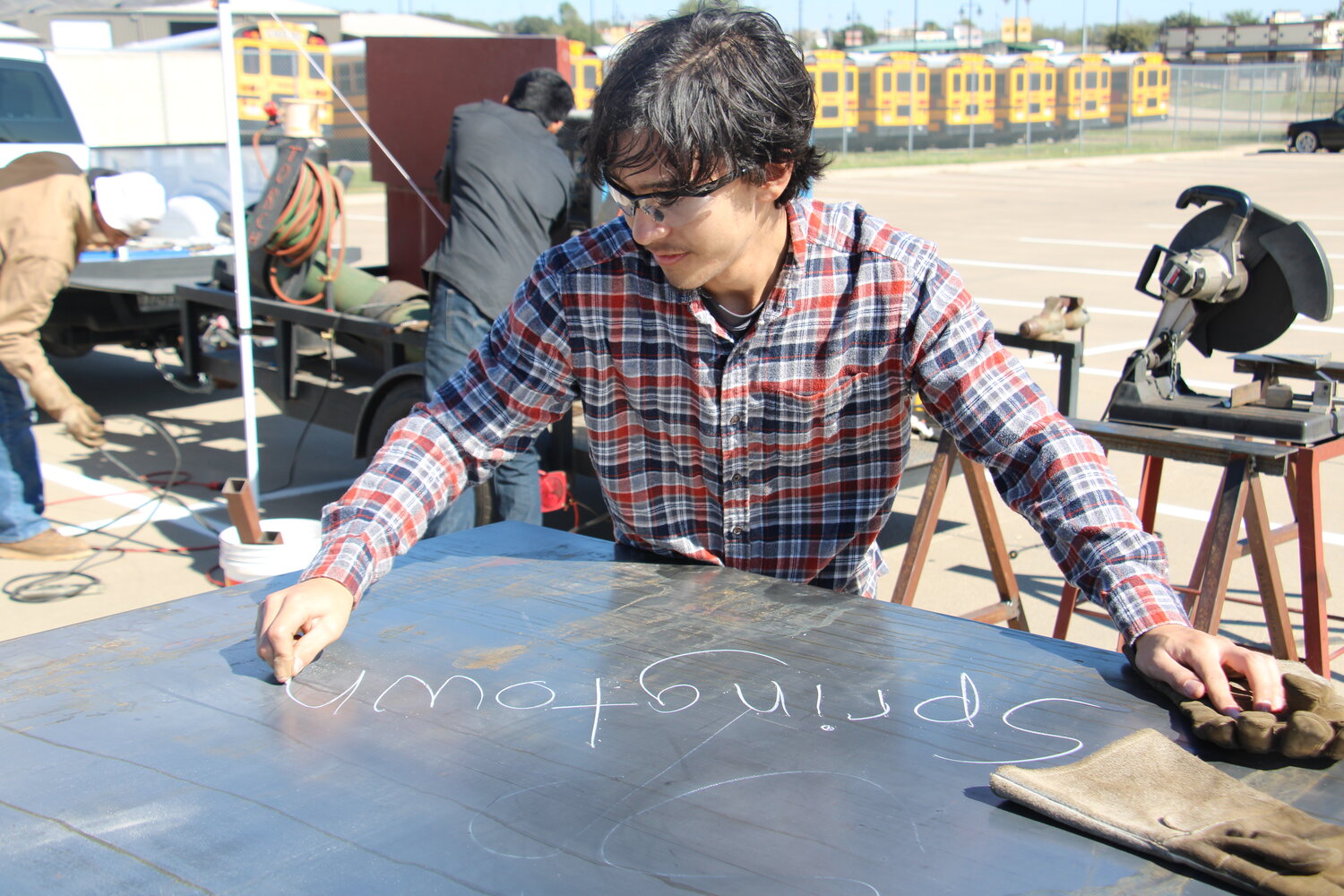Springtown High School senior Luke Holtman signs “Springtown” on his team’s finished project at SHS’ welding competition earlier this month.