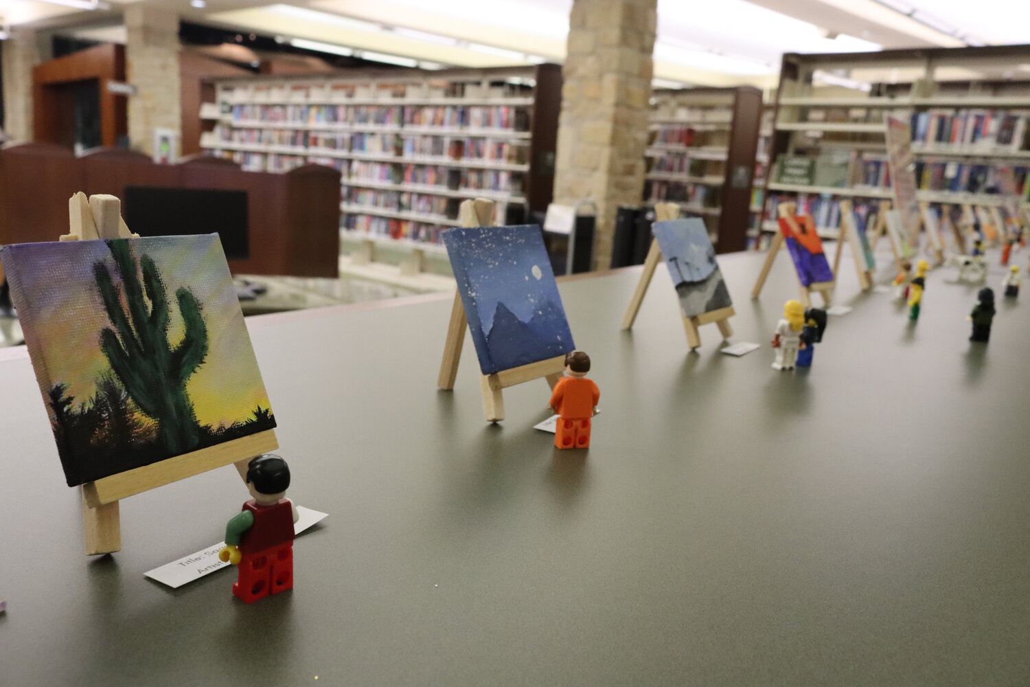 Lego minifig art appreciators pause to admire tiny paintings created by Azle teens and adults.