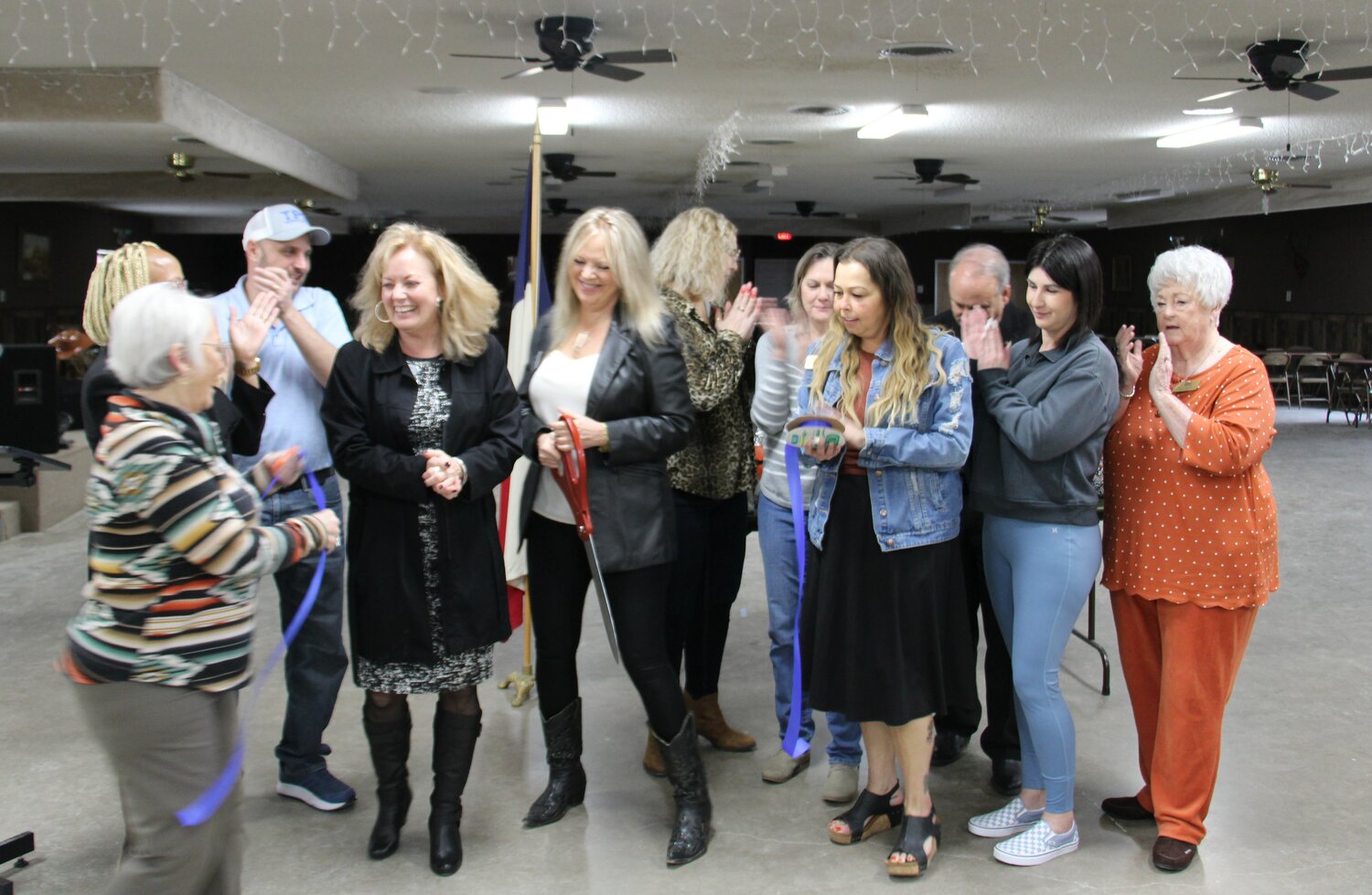 Springtown Area Chamber of Commerce ambassadors clap for Jane Faith, realtor at Coldwell Banker Apex Realtors, and Jill Sebik, senior loan officer at Platinum Eagle Mortgage, after honoring them with a ribbon cutting.