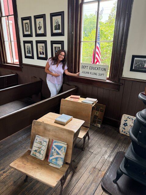 Ladye standing beside the sign that is displayed in the window of the upstairs courtroom at the Old Courthouse Museum. Her father was the Superintendent of Education for the Iuka School District at one time.