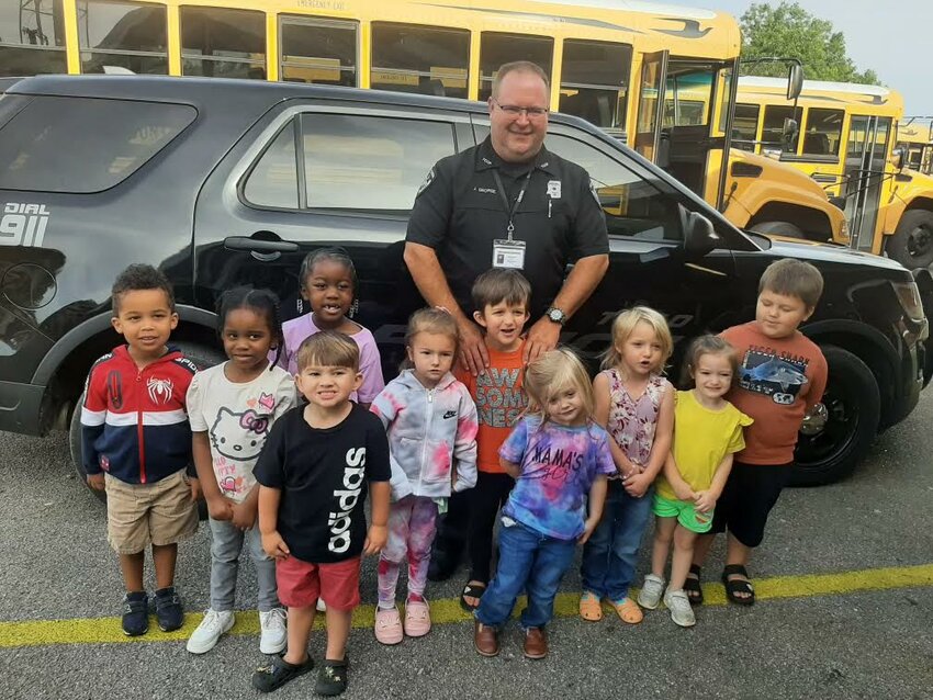 Jared George Standing in Front of His Patrol Car with Students of Tishomingo Headstart