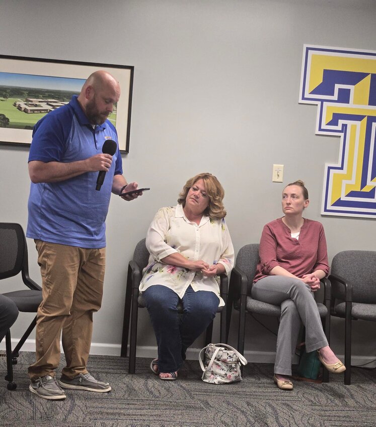 Christine Cook (C) and Melissa LaShure (R) listen as Triton Junior-Senior High School Principal Nathan McKeand gives his building update. Cook is retiring as the elementary school principal and LaShure was approved as the new elementary school principal.