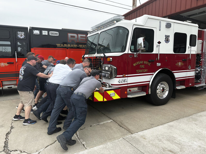 Warsaw-Wayne Fire Territory firefighters “push” the new engine 17 into the bay at station 17 Friday as part of a push in ceremony for the truck.