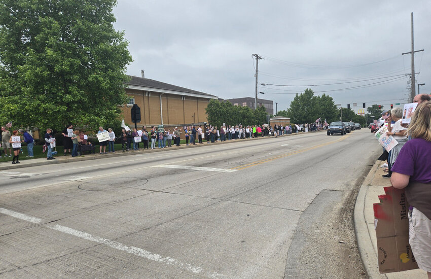 People line along Detroit Street Saturday during a “No Kings” rally.