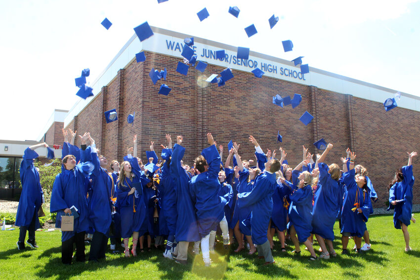 Members of the class of 2024 celebrate their graduation by throwing their caps in the air following the ceremony on Saturday.