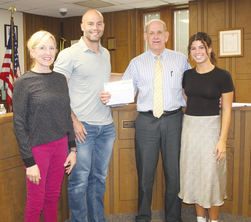 Involved in the dividend check presentation were (left) Council President Jill Brodersen, Mayor Cale Giese, Carter (Cap) Peterson and Peterson's granddaughter, Noelle Hinsley.