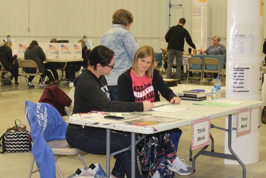 Poll workers Katie Wynia, Molly Redden and Irene Mock(with back to camera) work to verify voter information during Tuesday's election.