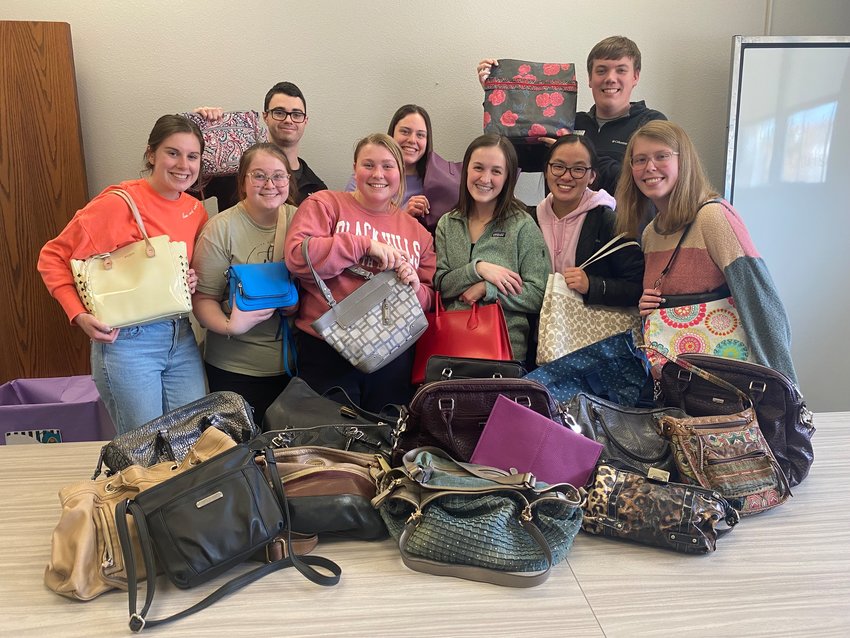 Wayne State College Navigators pose with some of the purses that were donated during the recent purse and hygiene kit service project. The purses were delivered to Haven House in Wayne and Bright Horizons in Norfolk.