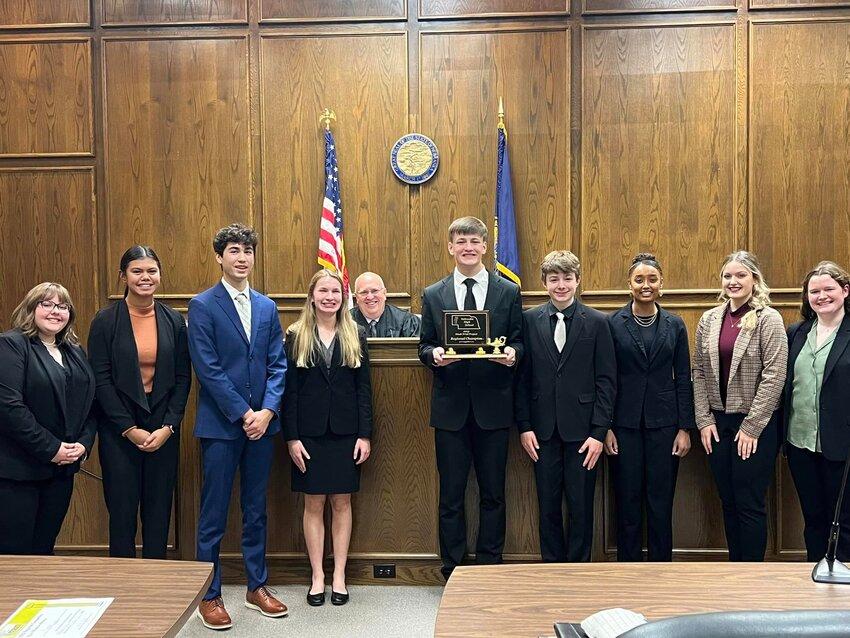 Mock Trial team members earning the right to take part in state competition include (left) Maddie Franta, Liberty Titiml, Mason Ley, Ava Elliott, Parker Kesting, Aidan Bohnert, Nyamalo Kantai, Adrienne Anderson and Jordan Clinchard. They are pictured with Nebraska Supreme Court Justice Cassel.
