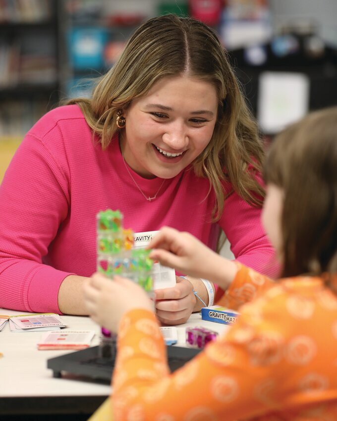 Wayne State College student Kennedy Whitney works with a student on a gravity maze exercise during Family Math, Science, and Art Night held recently at Wayne’s St. Mary’s Catholic School.