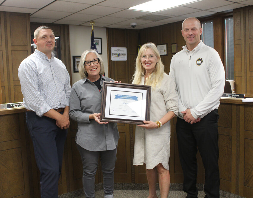 Involved in the presentation of the recertification plaque from the Nebraska Department of Economic Development (NDED) were (left) Luke Virgil, Director of Wayne America, Inc., Deb Poehling with NDED, Jill Brodersen, Council President, and Mike Powicki, chair