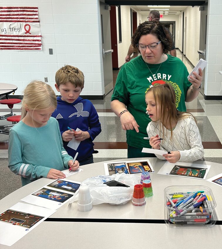 Around the table working on a project are (left) Eva Thies, Mathew Jeffery and Evie Dankert with Principal April Knust.
