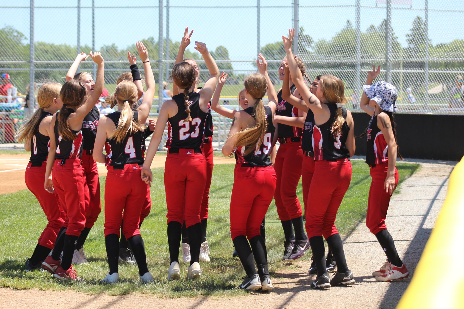 The 12-under softball squad gets fired up prior to taking the field during action at the district tournament.