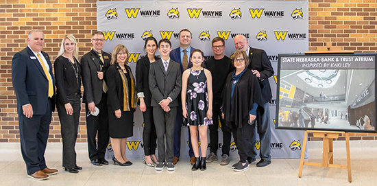 Involved in the surprise naming ceremony were (left) Kevin Armstrong, CEO of the Wayne State Foundation; Laura Robinett, Director of Major Gifts; Dr. David Bohnert, Chair of the WSC Music Department; Dr. Marysz Rames, President of Wayne State College; and the Ley Family including Sandy Brown, Mason Ley, Matt Ley, Josie Ley, Roy Ley, Kaki Ley and David Ley.